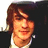 Pixelated portrait of a person with brown hair and a white shirt against a blue background with text.
