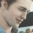 Pixelated image of a person with light skin and dark hair holding a microphone, next to red text on black background reading "ATTENTION ALL BOYS!!! READ TWILIGHT BE EDWARD!".