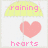 Pixelated icon shows yellow umbrella with pink text 'raining' above a large pink heart and pink text 'hearts' below on white background.