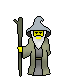 Pixelated wizard figure with gray hat, white beard, yellow face, and green robe holding a staff against gray background.