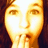 Pixelated image of a person with hands near mouth on left, pink text on black background on right.