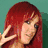 A static image of a person with long red hair and a green background, making a peace sign with their hand.
