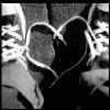 Black-and-white image of two sneakers forming a heart shape with their laces, viewed from above.
