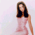 A pixelated static image of a woman with long dark hair wearing a light pink sleeveless dress against a pale background.