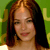 A pixelated close-up of a person with long brown hair against a green background with yellow accents.