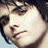 Pixelated close-up of a person's face with dark hair, showing eyes and part of the nose against a light background.