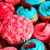 Pixelated image of pink and blue floral shapes with dark brown accents, no visible text or distinct figures.