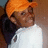 Pixelated image of a person wearing an orange cap and white shirt on a red background with black text.