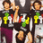 Pixelated image of two figures in dark clothing with green and yellow symbols, one figure holding a raised arm.
