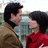 Two people in a brown jacket and red top stand close together, with text overlay reading 'the lake house<3' in pixelated font.