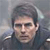 Pixelated static image of a person with short dark hair wearing a dark jacket against a blurred background.
