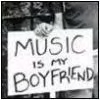 Black-and-white image of a hand-drawn sign reading "MUSIC IS MY BOYFRIEND" with a small flower drawing above the text.