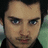 Pixelated image of a person with dark hair and blue eyes, overlaid with distorted white text on black background.