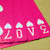 Animated pink banner with white cloud and '2010' text, transitioning to a circular arrangement of silver and blue objects around a heart, then to a colorful spinning flower, and finally to black hand silhouettes on colored backgrounds.