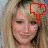 A static image of a person with long light brown hair wearing a red heart-shaped headband, smiling slightly against a blurred background.