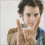 A person in a brown jacket and blue shirt makes hand gestures with text changing around them across four