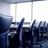 Blue background with pixelated text and a small blurry office scene in the top-left corner.
