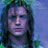 Pixelated static image of a person's face with long dark hair against a blue background, rendered in low-resolution 256x256 pixels.