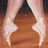 A ballet dancer's feet in pointe shoes perform a sequence of poses on a wooden floor, transitioning from fifth position to an extended arabesque.