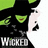 Pixelated green background with a black-and-white character image and multiple text blocks including 'WICKED' and 'Defy Gravity!!!'