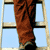 A 4-frame contact sheet animation of a person in brown pants and blue denim jacket performing actions on a ladder against a light blue background.