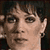 Static pixelated image of a person's face with visible facial features and hair, rendered in low resolution on a dark background.