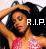 Pixelated static image of a person with dark hair wearing headphones, holding an object near their face, with "R.I.P." text on the right side against a black background.