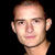 Static pixelated portrait of a person with short hair against black background, rendered in low-resolution 256x256 pixels with visible dithering and color blending.
