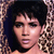 Pixelated close-up of a person with dark hair and light skin, wearing a large earring, against a patterned background.