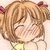 Pixelated anime-style character with light brown hair, closed eyes, and a smiling expression, wearing a yellow top and red hair bows.