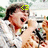 A pixelated image of a person in a white shirt holding a microphone, with green text above the head changing from '<3' to 'love'.