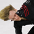 Static 50x50 pixel buddy icon showing a person with blonde hair in black clothing and red accents, viewed from an angle against a plain background.