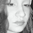 Pixelated grayscale image of a person's face with visible eyes, nose, mouth, and hair, cropped to show only the upper portion of the head.