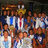Group of people in sports uniforms holding a trophy, with one person wearing a crown, in a pixelated animation.