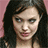 Static pixelated image of a person with long dark hair against a pink background, wearing light-colored clothing.