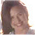 Static pixelated image of a person with long brown hair, light skin, and a neutral expression, cropped to show head and shoulders against a light background.