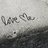 A split-screen image with a grayscale background on the left and solid red on the right, displaying pixelated text 'love me.' in black on both sides.