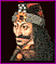 Pixelated portrait of a person with long dark hair and beard, wearing a fur-lined hooded garment against a black background.