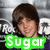 A pixelated image of a person with brown hair and a purple shirt, featuring text overlays in green, cyan, and red with phrases like 'Sugar', 'Ranch', 'Sugar R', and 'LuvS JB!'.