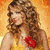 A woman with curly brown hair wears a yellow dress with a red flower on the chest against an orange background.