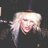 Pixelated image of a person with light-colored hair and closed eyes, set against dark background.
