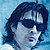 Pixelated static image of a person with dark hair and light skin against a blue background, rendered in low-resolution style typical of early internet icons.