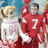 Pixelated image of a person in red sports uniform with number 7, holding a large trophy and white star-shaped object against blue background.