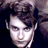 Static pixelated image of a person's face with dark hair and light skin, rendered in low resolution with visible dithering and color banding against a dark background.