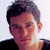 Static 50x50 pixel buddy icon showing a close-up of a person's head and shoulders with dark hair, visible ear, and black clothing against a light background.