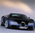 Pixelated image of a dark-colored sedan with blue accents on a light background, viewed from a low angle with a bright light source in the upper right.