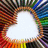 A static pixelated image with a central white oval surrounded by a multicolored border of brown, red, orange, green, blue, and purple hues.