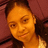 Pixelated close-up of a person with light skin tone, dark hair, and warm-toned lighting against a reddish-brown background.