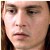Pixelated close-up of a person's face with light skin tone, dark brown eyes, and dark hair visible on the left side, cropped to show only the upper face.
