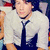 A person in a white shirt and dark tie appears in a of four with slight variations in pose and background elements